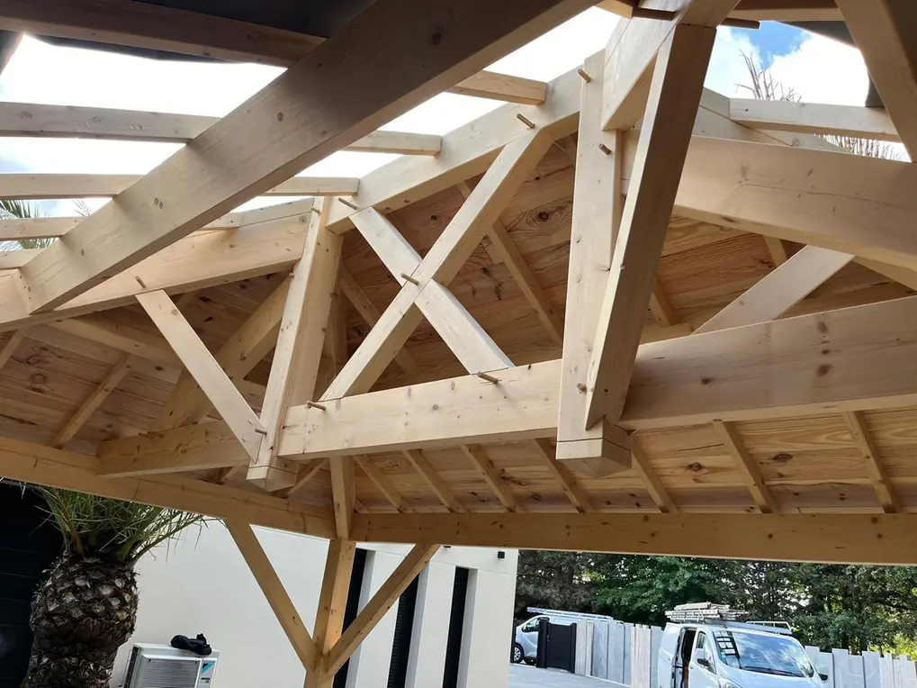 Charpente d'un abri vue du dessous, assemblages et contreventement apparents