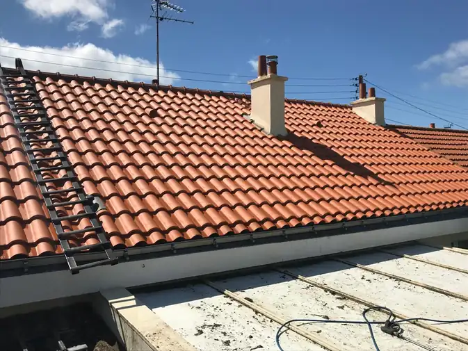 Toiture en tuiles d'une maison de lotissement, lignes aériennes au-dessus