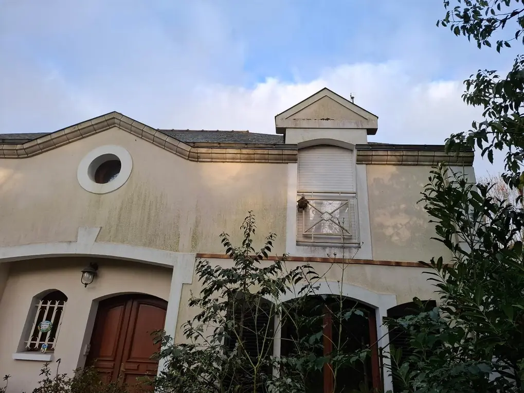 Façade ancienne encrassée, encadrements de pierre et porte bois