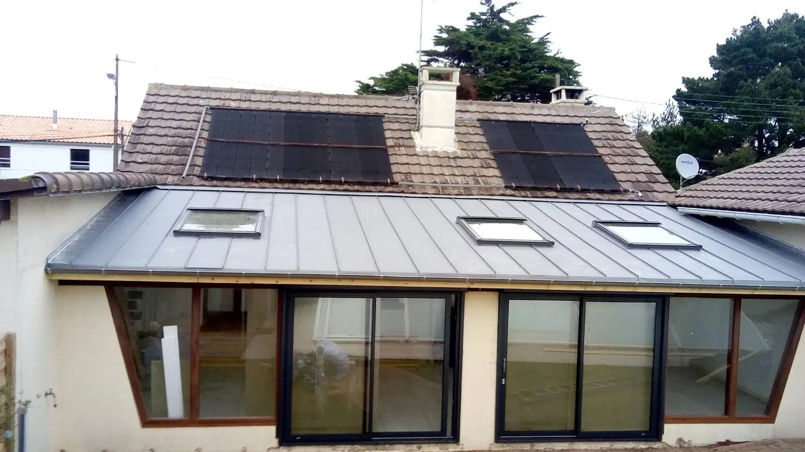 Couverture en zinc équipée de panneaux solaires et de fenêtres de toit