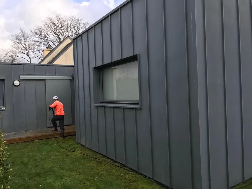 Bardage et couverture en zinc d'une extension, compagnon au pied du mur