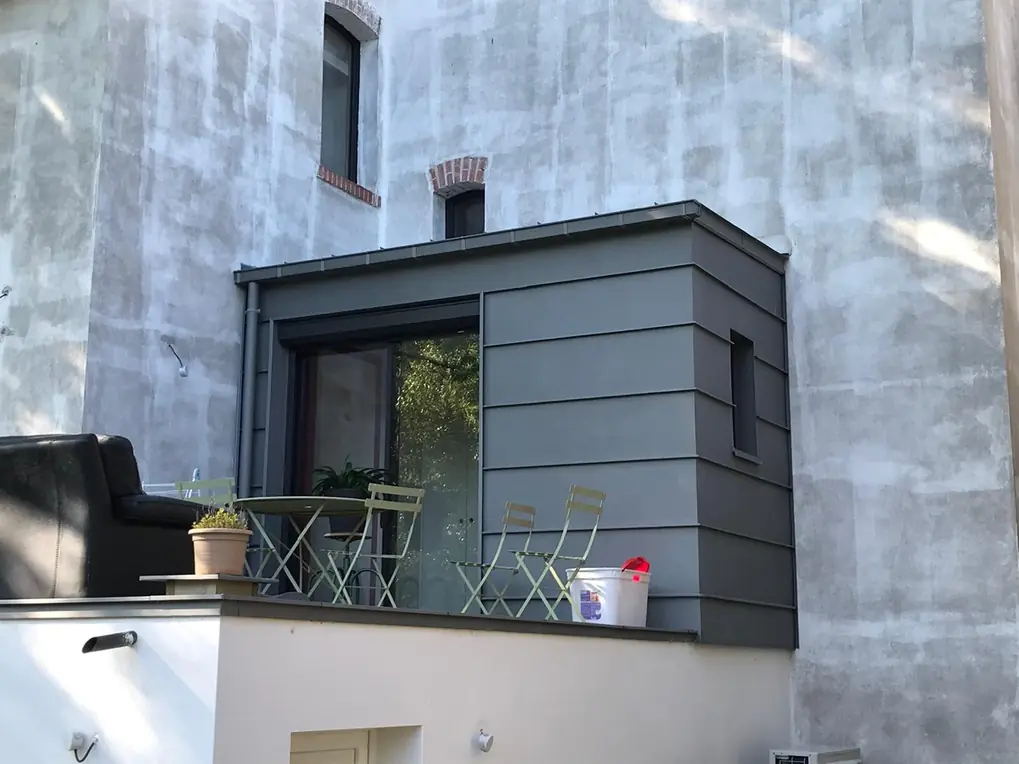 Extension couverte en zinc gris vue depuis la terrasse