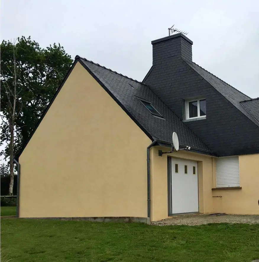 Maison à façade claire après remise en état, toiture en ardoise